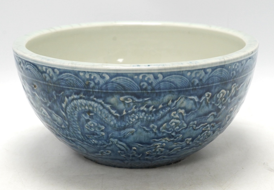 A large Chinese blue and white ‘dragon’ bowl decorated in low relief, 28cm in diameter. Condition - good